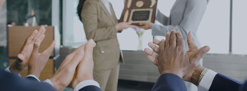 Person receiving award in front of a clapping audience